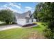 View of the home's side and garage featuring white siding, black shutters, and a well-manicured lawn at 2735 Clifton Ave, Creedmoor, NC 27522