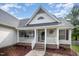 Charming front porch with white railings, brick accents, hanging plants, and a welcoming entrance at 2735 Clifton Ave, Creedmoor, NC 27522