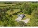 A stunning aerial view of a home with a backyard pool, a long private drive, and surrounded by beautiful trees at 3010 Blueberry Ln, Chapel Hill, NC 27516