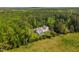 An aerial shot showcases the property, which includes a pool, detached garage, and a home surrounded by lush greenery at 3010 Blueberry Ln, Chapel Hill, NC 27516