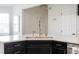 Close-up of kitchen island featuring white countertop, black cabinets, and gold fixtures at 3010 Blueberry Ln, Chapel Hill, NC 27516