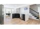 Modern kitchen island with marble countertop, black cabinets, and view of the adjacent dining area at 3010 Blueberry Ln, Chapel Hill, NC 27516