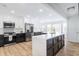 Bright, open kitchen with an island, stainless steel appliances, and modern white and black cabinets at 3010 Blueberry Ln, Chapel Hill, NC 27516