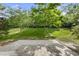 The backyard has a stone patio surrounded by green grass and trees offering a private outdoor space at 3033 Remington Oaks Cir, Cary, NC 27519