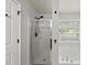 A modern bathroom features a glass-enclosed shower and a separate soaking tub beneath a window at 3033 Remington Oaks Cir, Cary, NC 27519