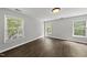 A sunlit bedroom with wood-look flooring is brightened by verdant views through the windows at 3033 Remington Oaks Cir, Cary, NC 27519