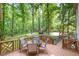 Outdoor dining on the deck, surrounded by a lush green forest, perfect for enjoying meals and nature at 309 Appaloosa Trl, Bahama, NC 27503