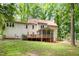 Backyard view of a house with a deck, screened porch, and ample green space, ideal for outdoor activities at 309 Appaloosa Trl, Bahama, NC 27503