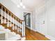 Welcoming foyer featuring hardwood floors, staircase with wooden railing, and an inviting front door at 309 Appaloosa Trl, Bahama, NC 27503