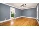 Bright living room with hardwood floors, an elegant ceiling fan, and plenty of natural light from large windows at 309 Appaloosa Trl, Bahama, NC 27503