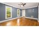 Bright living room with hardwood floors and an elegant ceiling fan, with large windows at 309 Appaloosa Trl, Bahama, NC 27503