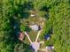Aerial view of home surrounded by trees, with a long driveway and outbuilding offering a secluded and serene atmosphere at 318 Duck Pond Ln, Clayton, NC 27520