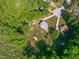 Expansive aerial view of home nestled among trees with private driveway, outbuilding, and mature landscaping at 318 Duck Pond Ln, Clayton, NC 27520