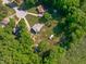 Serene aerial view of home with a long driveway, outbuilding, and lush tree canopy creating a private oasis at 318 Duck Pond Ln, Clayton, NC 27520