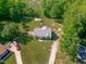 Stunning aerial view of home with lush landscaping, long private driveway, and additional outbuilding at 318 Duck Pond Ln, Clayton, NC 27520