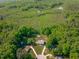 Overhead view of beautiful property with a house, long driveway, outbuilding, and surrounded by lush forests and scenic landscape at 318 Duck Pond Ln, Clayton, NC 27520