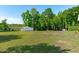 Grassy backyard featuring mature trees and lush greenery, with a small storage shed at 318 Duck Pond Ln, Clayton, NC 27520