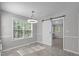 Open dining room area with large window and a modern sliding barn door at 318 Duck Pond Ln, Clayton, NC 27520