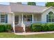 Inviting front porch with a white railing and brick steps, surrounded by lush greenery at 318 Duck Pond Ln, Clayton, NC 27520