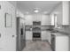 A well-lit kitchen featuring stainless steel appliances, ample white cabinetry, and granite countertops at 318 Duck Pond Ln, Clayton, NC 27520