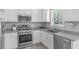 A well-lit kitchen featuring stainless steel appliances and light granite countertops at 318 Duck Pond Ln, Clayton, NC 27520