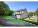 Expansive backyard with lush lawn, screened porch, and multi-car garage surrounded by mature trees at 3209 Bryant Falls Ct, Raleigh, NC 27613