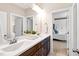 Bathroom with double vanity, dark wood cabinets, and a doorway view into bedroom at 3209 Bryant Falls Ct, Raleigh, NC 27613
