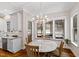 Breakfast area with a marble table, chairs, and a view of the screened porch and backyard at 3209 Bryant Falls Ct, Raleigh, NC 27613