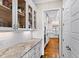 Butler's pantry with granite countertops, glass front cabinets, and a view into the bright kitchen at 3209 Bryant Falls Ct, Raleigh, NC 27613