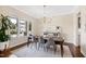 Dining room with a long wooden table, seating, a chandelier, and a large window with neighborhood views at 3209 Bryant Falls Ct, Raleigh, NC 27613