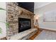 Stone fireplace featuring a gas insert, stone mantel, and mounted television creating a cozy focal point at 3209 Bryant Falls Ct, Raleigh, NC 27613