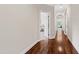 Hallway with hardwood floors leading to rooms, offering a glimpse of a bright interior at 3209 Bryant Falls Ct, Raleigh, NC 27613