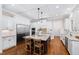 Bright, open kitchen featuring a large island, stainless steel appliances, and white cabinetry and hardwood floors at 3209 Bryant Falls Ct, Raleigh, NC 27613