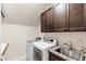 Laundry room with a washer, dryer, upper cabinets, and a sink with granite countertop at 3209 Bryant Falls Ct, Raleigh, NC 27613