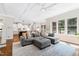 Bright living room featuring coffered ceilings, recessed lighting, a gray sofa, and large windows at 3209 Bryant Falls Ct, Raleigh, NC 27613