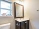 Bathroom vanity with a dark wood cabinet, white countertop, framed mirror, and modern fixtures at 33 Juliette Dr, Durham, NC 27713