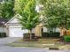 Charming single-Gathering home featuring a spacious two-car garage, manicured lawn, and mature trees at 33 Juliette Dr, Durham, NC 27713