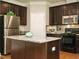 Modern kitchen featuring stainless steel appliances, dark wood cabinets and a center island with granite countertops at 33 Juliette Dr, Durham, NC 27713