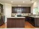 Well-appointed kitchen boasting dark wood cabinetry, a granite island, stainless steel appliances, and modern backsplash at 33 Juliette Dr, Durham, NC 27713