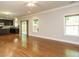 Spacious living room with hardwood floors and lots of natural light from the adjacent kitchen and multiple windows at 33 Juliette Dr, Durham, NC 27713