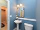 This powder room features a pedestal sink, a decorative mirror, and a toilet at 3339 Archdale Dr, Raleigh, NC 27614