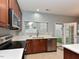 Well-lit kitchen featuring stainless steel appliances and a view to the backyard through double doors at 3339 Archdale Dr, Raleigh, NC 27614