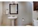 Bathroom with a pedestal sink, dark wood mirror, and a toilet at 3357 Denise St, Durham, NC 27704