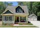 Charming home with a covered front porch, dark shutters, and a detached two-car garage at 3357 Denise St, Durham, NC 27704