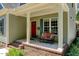 Inviting front porch with a seating bench, decorative pillows, and a bright red front door at 3357 Denise St, Durham, NC 27704