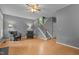 Inviting living room with hardwood floors, gray walls, ceiling fan, and staircase access at 3401 Scotch Dr, Raleigh, NC 27616