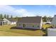 Backyard view of home with sliding glass door, gray siding, and lush lawn at 36 High View Ct, Fuquay Varina, NC 27526