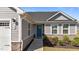 Close-up of the front entrance, showcasing a blue door, stone accents, manicured landscaping, and a two-car garage at 36 High View Ct, Fuquay Varina, NC 27526