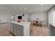 Open concept kitchen showcasing the island with a quartz countertop, dining table, and living room at 36 High View Ct, Fuquay Varina, NC 27526