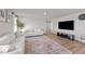Spacious living room with wood floors, white sofas, media center, and bright natural light at 36 High View Ct, Fuquay Varina, NC 27526